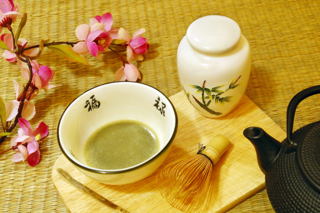 Tools used for Japanese tea ceremony (chado). A brush made of bamboo and a teacup with green tea called matcha on wooden tray.